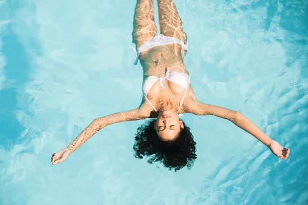 Schöne Frau im weißen Bikini schwimmend — Stockfoto