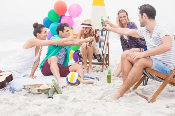 Grupo de amigos brindando garrafas de cerveja na praia — Fotografia de Stock