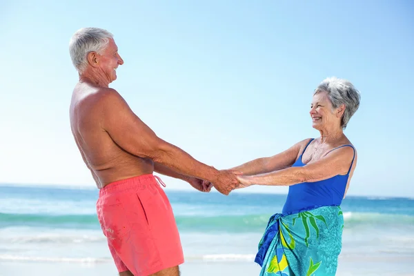 Мила зріла пара тримає руки на пляжі — стокове фото