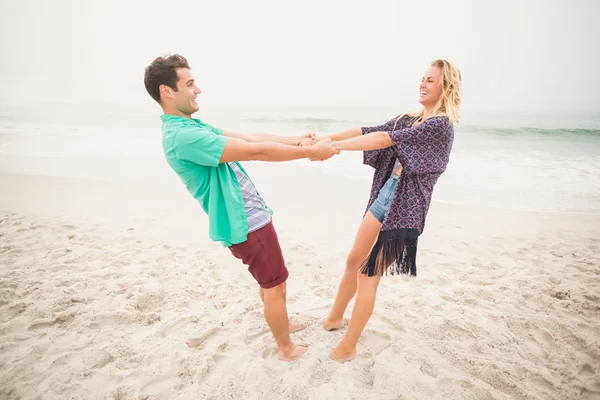 Felice coppia che si tiene per mano sulla spiaggia — Foto Stock