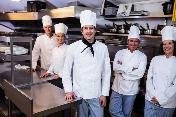 Equipe de chefs de pé na cozinha comercial — Fotografia de Stock