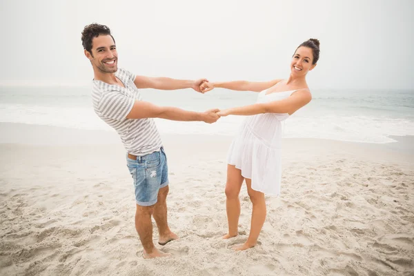 Felice coppia che si tiene per mano sulla spiaggia — Foto Stock