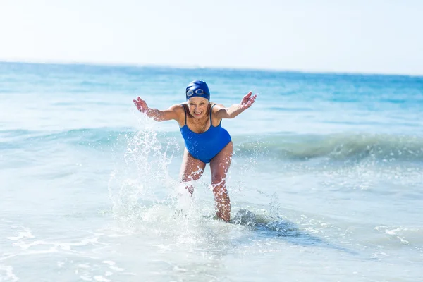 Mooie rijpe vrouw spelen op het strand — Stockfoto