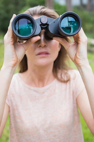 Woman using binoculars — Stock Photo, Image