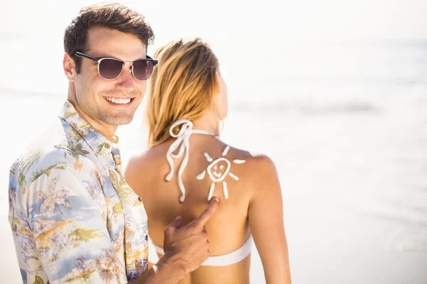 Hombre haciendo un símbolo del sol en las mujeres espalda — Foto de Stock