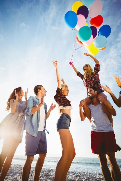 Vrienden dansen op zand met ballon — Stockfoto