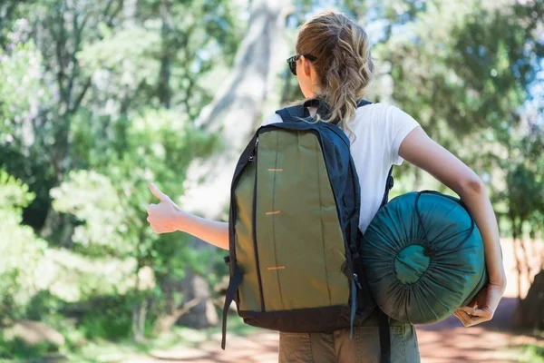 Hitch hiking woman with sleeping bag — Stock Photo, Image