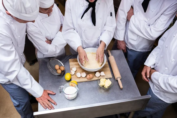 Head chef teaching his team to prepare a dough — Stock Photo, Image