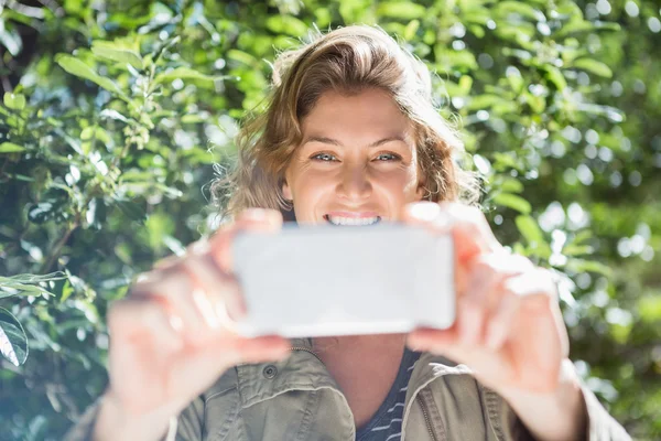 Femme souriante prenant selfies — Photo
