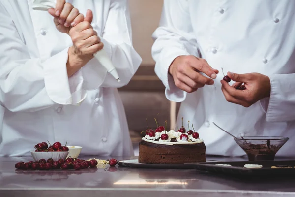 Chefs décorant un gâteau qu'ils viennent de faire — Photo