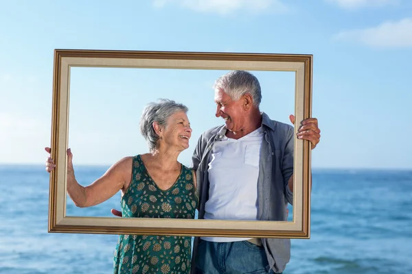 Senior paar posiert mit einem Rahmen — Stockfoto