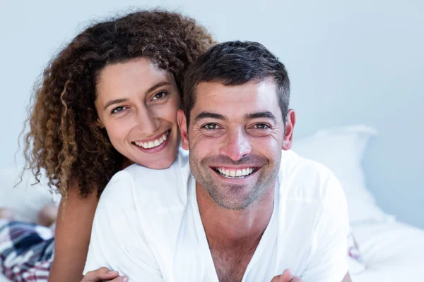 Portrait of happy couple lying on bed — Stock Photo, Image