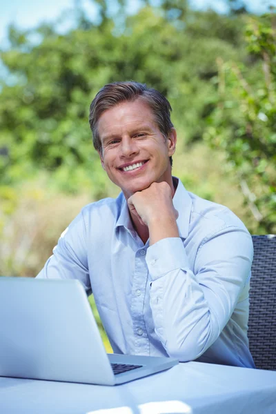 Uomo d'affari sorridente utilizzando il computer portatile — Foto Stock