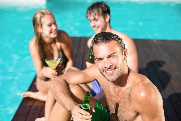 Jonge man met bier bij het zwembad — Stockfoto