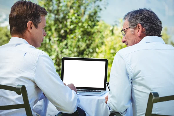 Dos hombres de negocios que se reúnen en un restaurante usando laptop — Foto de Stock