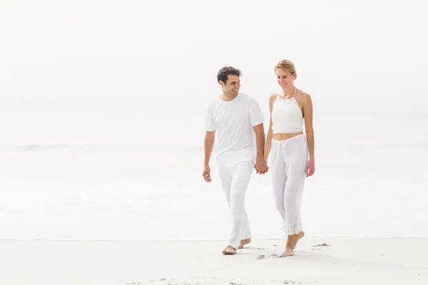 Feliz jovem casal andando na praia — Fotografia de Stock