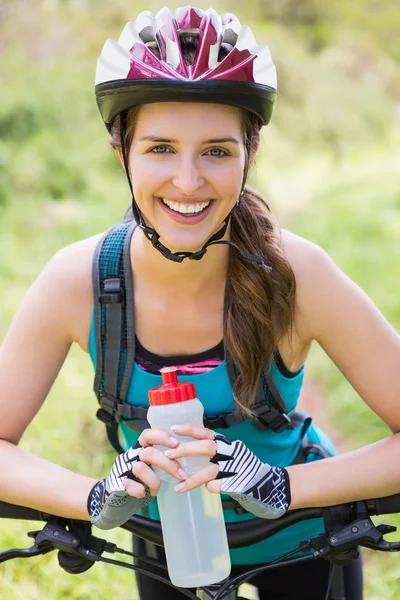 Bisikletini yanında duran gülümseyen kadın — Stok fotoğraf