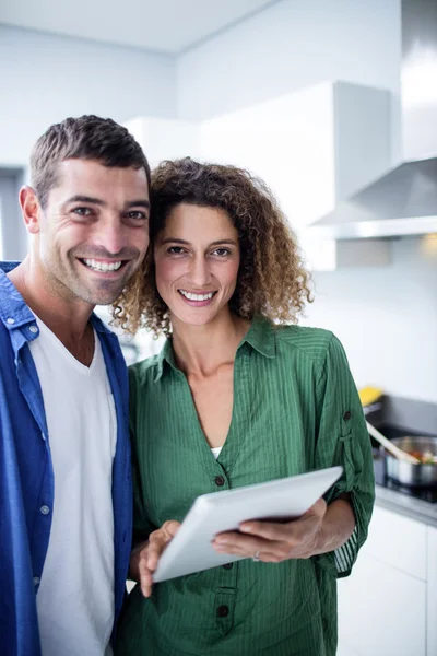 Retrato de pareja usando tableta digital en la cocina — Foto de Stock