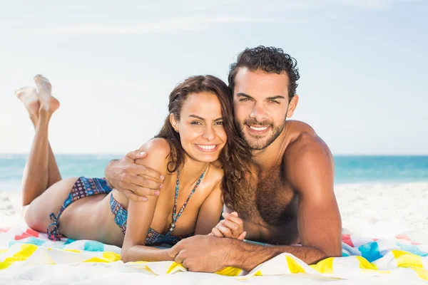 Paar liegt auf einem Handtuch am Strand — Stockfoto