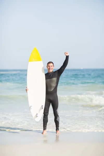 Щасливий чоловік тримає дошку для серфінгу на пляжі — стокове фото