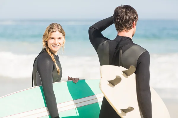 幸福的夫妇与冲浪板站在海滩上 — 图库照片