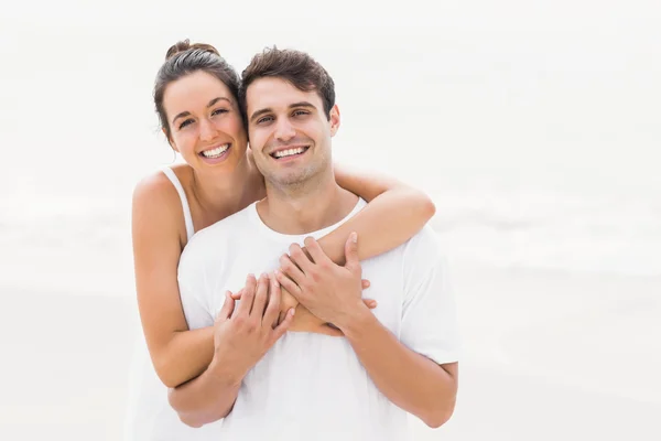 Porträt eines jungen Paares, das sich am Strand umarmt — Stockfoto