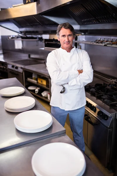 Chef sorridente com as mãos cruzadas na cozinha — Fotografia de Stock