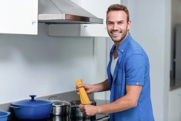 Junger Mann kocht Spaghetti — Stockfoto