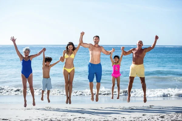 Lycklig familj hoppar på stranden — Stockfoto