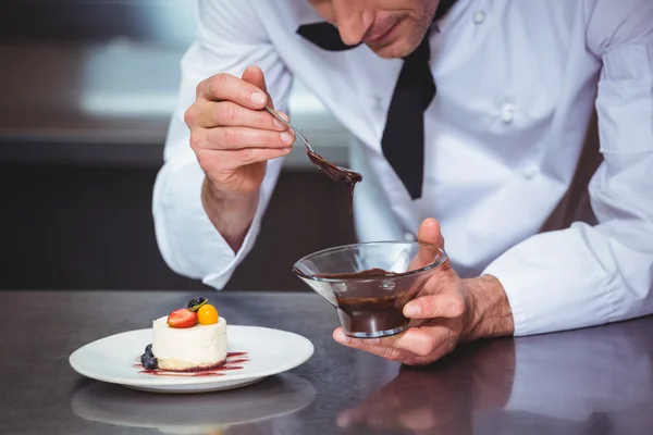 Chef poniendo salsa de chocolate en un postre —  Fotos de Stock