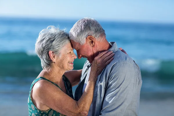 Casal sênior abraçando na praia — Fotografia de Stock