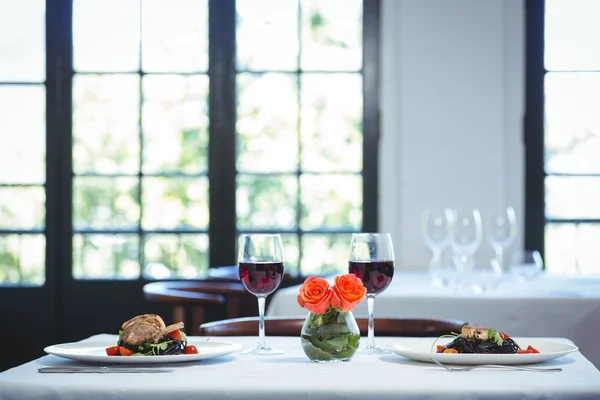 Inktvis inkt spaghetti schotel met basilicum voor twee met glazen rood — Stockfoto