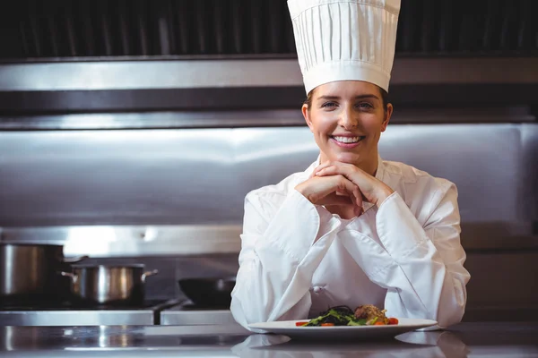 Chef leaning on the counter with a dish — Stock Photo, Image