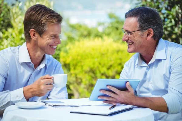 Dois empresários que se reúnem em um restaurante usando tablet — Fotografia de Stock