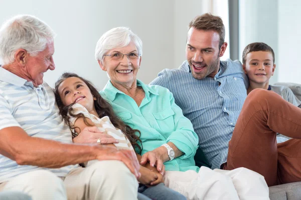 Família feliz sentado no sofá — Fotografia de Stock