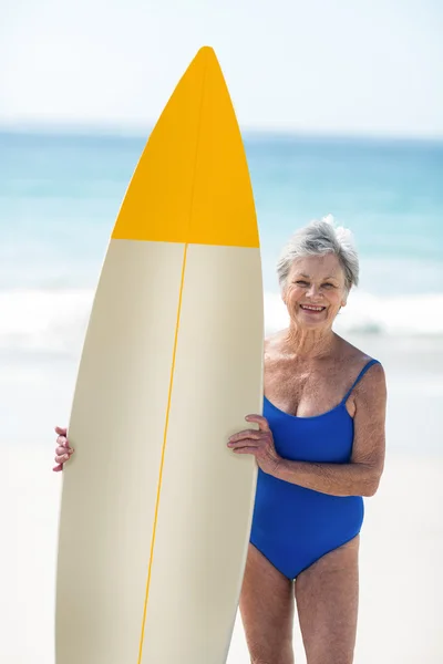 Mulher madura posando com uma prancha de surf — Fotografia de Stock