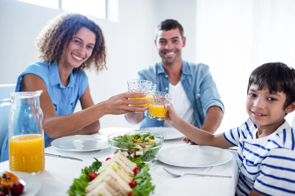 Retrato de família brindar copos de suco de laranja, tendo — Fotografia de Stock