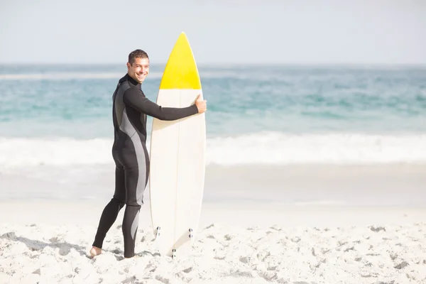 Uomo felice che tiene una tavola da surf sulla spiaggia — Foto Stock