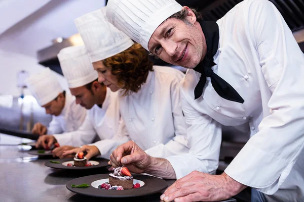 Équipe de chefs finition assiettes à dessert — Photo