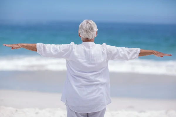 Achteraanzicht van volwassen vrouw poseren met uitgestrekte armen — Stockfoto