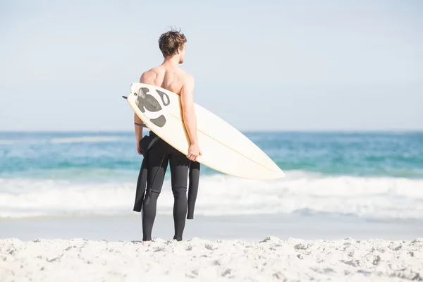 Homme avec planche de surf debout sur la plage — Photo