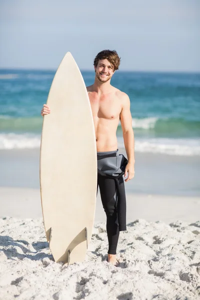 Glücklicher Mann mit Surfbrett am Strand — Stockfoto