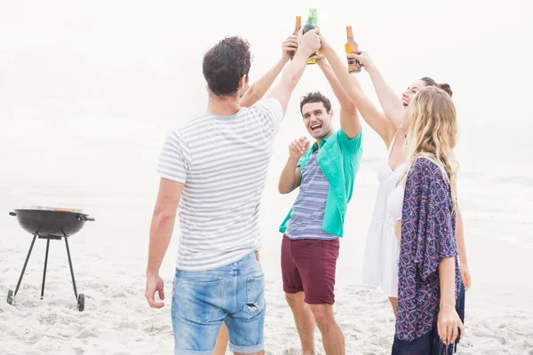 Groep vrienden roosteren bierflessen op het strand — Stockfoto