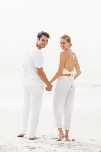 Portret van gelukkige paar staande op het strand — Stockfoto