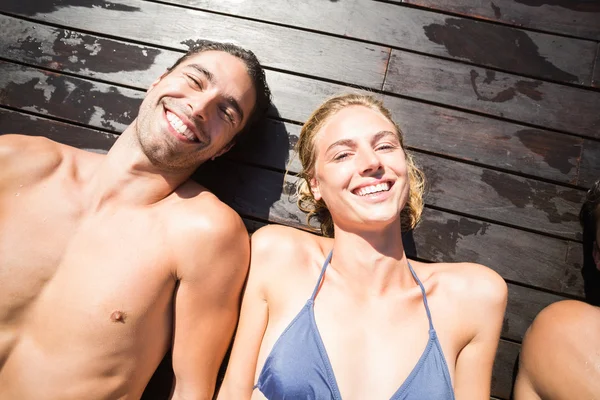 Pareja sonriente relajándose en cubierta de madera —  Fotos de Stock