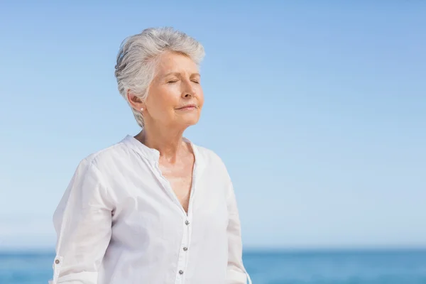 Senior mulher relaxante na praia — Fotografia de Stock