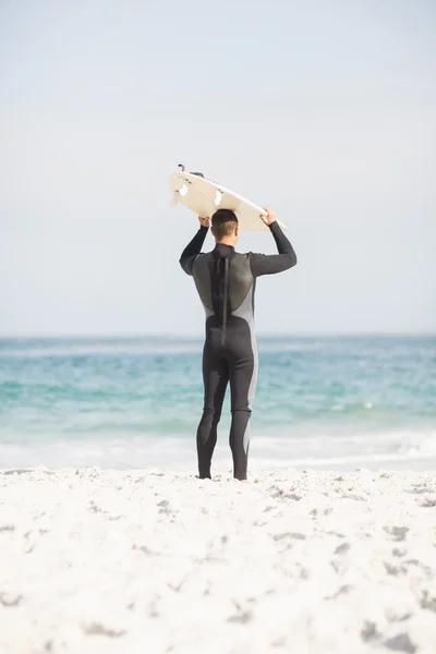 Vedere din spate a omului care deține placa de surf deasupra capului — Fotografie, imagine de stoc