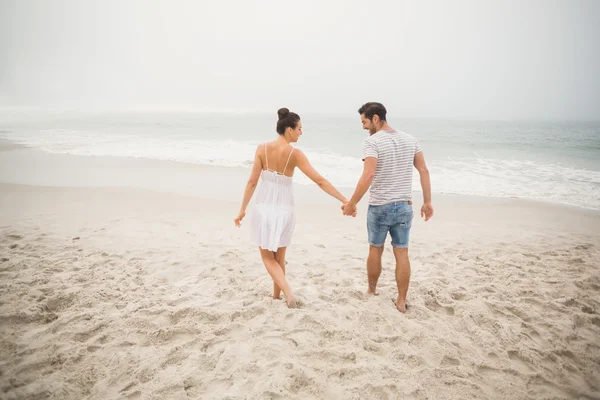 Achteraanzicht van paar, houdend handen en wandelen op het strand — Stockfoto