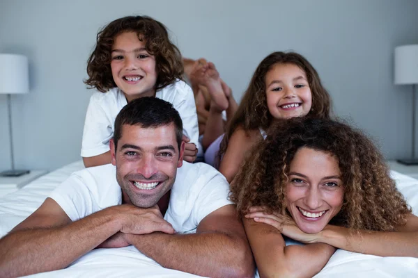 Porträtt av familj liggande på varandra — Stockfoto