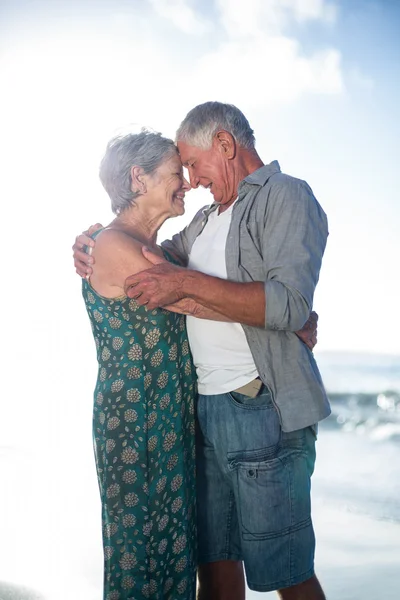 Seniorenpaar umarmt sich am Strand — Stockfoto